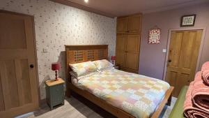 une chambre avec un lit avec une tête de lit en bois dans l'établissement Hideaway cottage, à Kirkhamgate