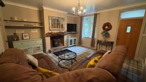 un salon avec un canapé et une cheminée dans l'établissement Hideaway cottage, à Kirkhamgate
