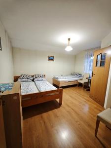ein Zimmer mit zwei Betten und Holzboden in der Unterkunft Domek nad wodospadem in Zakopane + 24 Fotos