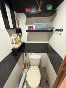 ein Badezimmer mit einer weißen Toilette in einem Zimmer in der Unterkunft Studio Apt Cinere in Karangtengah