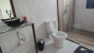 een badkamer met toilet, douche en wastafel bij Pousada Casa da Praia in Passo de Torres +29 foto's