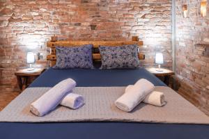 帕拉塔蒙Villa Nestor的一间卧室配有带枕头的床和砖墙