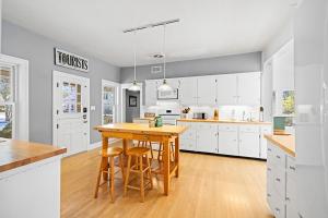 a kitchen with white cabinets and a wooden table at Berrywood Farm in Lakeside