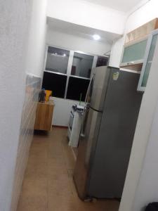 a kitchen with a stainless steel refrigerator in a room at Apto 2 dorm com elevador in São Vicente
