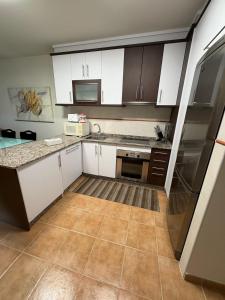 a kitchen with white cabinets and a counter top at Portosín beach apartment in Goyanes