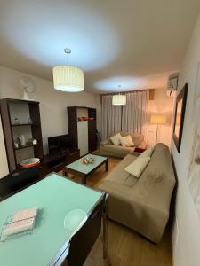 a living room with a couch and a table at Portosín beach apartment in Goyanes +2 photos