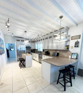 a large kitchen with white cabinets and a large island at Waterfront Boat Lift Bungalow in St Pete Beach
