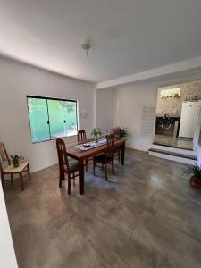 una sala da pranzo con tavolo, sedie e una finestra di Apartamentos e Suites Casa Verde a Búzios