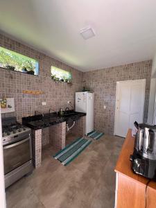 una cucina con fornelli e frigorifero di Apartamentos e Suites Casa Verde a Búzios