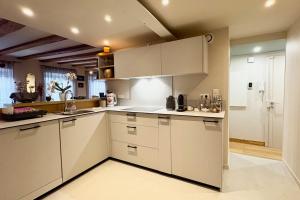 a kitchen with white cabinets and white appliances at Luxury apartment in the city center in Strasbourg