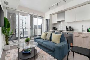ein Wohnzimmer mit einer blauen Couch in einer Küche in der Unterkunft Chic 2BR Condo Toronto Core Steps to Eaton Centre in Toronto