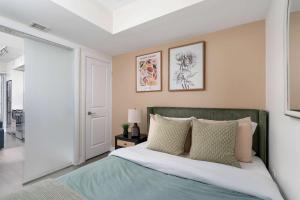 Schlafzimmer mit einem Bett mit einem grünen Kopfteil in der Unterkunft Chic 2BR Condo Toronto Core Steps to Eaton Centre in Toronto