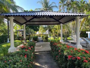 ein Pavillon mit Blumen in einem Park mit Palmen in der Unterkunft Pool • Game Room • Fire Pit • Resort Access in Los Cóbanos