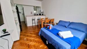 une chambre avec un lit bleu avec des serviettes dessus dans l'établissement Sunrise Flamengo - 4 Hóspedes, Metrô e Privativo!, à Rio de Janeiro