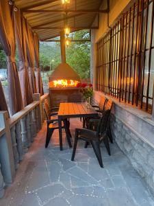 eine Terrasse mit einem Tisch, Stühlen und einem Kamin in der Unterkunft Halidzor Guest House in Halidzor