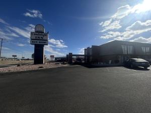 a sign for a parking lot in front of a building at Candlelight Inn by Capital O Scottsbluff in Scottsbluff