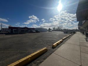 een lege parkeerplaats met de zon in de lucht bij Candlelight Inn by Capital O Scottsbluff in Scottsbluff