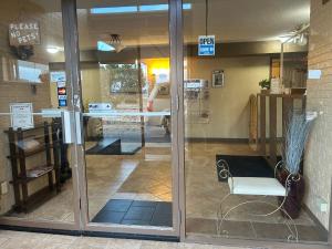 a glass door of a store with a table and a chair at Candlelight Inn by Capital O Scottsbluff in Scottsbluff +36 photos