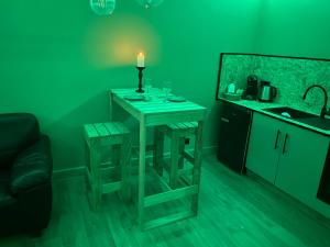a green room with a table with a candle on it at A La Mare du Vieux Chêne in Bellegarde-Poussieu