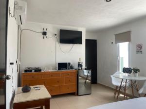 un salon avec une télévision au mur dans l'établissement Departamento TUL, à Mérida