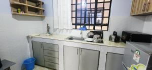 Una pequeña cocina con fregadero y ventana. en KeenStays Isiolo Town, en Isiolo
