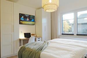a bedroom with a bed and a desk and a television at "Skandi-Lounge" - Naturnahe Ferienwohnung mit Kaffeebar, schnellem Internet und Wallbox in Beverstedt +40 photos
