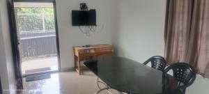 Una mesa de cristal y sillas en una habitación con ventana. en Honey Drops Homestay by Hebron, en Kanthalloor