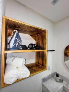 a bathroom with a shelf with towels and a sink at MHV Milagres - Casa Maria, Refugio em condomínio a poucos metros da paradisíaca praia do Marceneiro! in Passo de Camarajibe