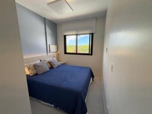 a bedroom with a blue bed and a window at Resort piscina aquecida suíte e churrasqueira in Florianópolis +12 photos
