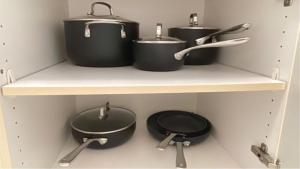 four pots and pans on a shelf in a kitchen at New Ocean View Condominium Free parking in Honolulu