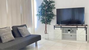 Una sala de estar con un sofá y un televisor en New Ocean View Condominium, en Honolulu