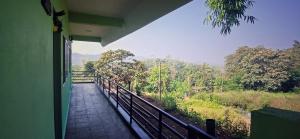 een balkon van een huis met uitzicht op een bos bij The Town Cascade in Madikeri