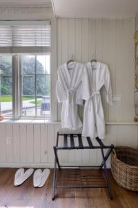 a rack with white shirts and flip flops and a window at Pool Cottage at Roundtop Estate couples oasis in Wrightsville