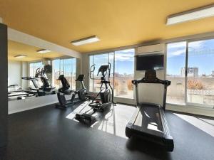 a gym with treadmills and ellipticals in a room with windows at Modern and Warm Apartment in Buenos Aires +12 photos