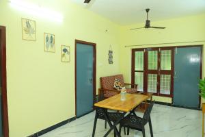 ein Esszimmer mit einem Holztisch und Stühlen in der Unterkunft Sandy Toes -Ocean Balcony 2BHK & 2mins to Promenade in Puducherry