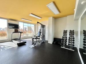 a gym with two treadmills and a chair in a room at Modern and Warm Apartment in Buenos Aires