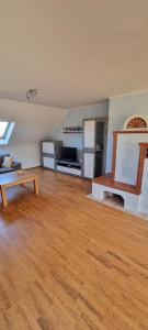 ein Wohnzimmer mit Holzboden und einem Tisch in der Unterkunft Ferien auf dem Lande 