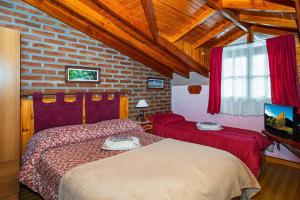 a bedroom with two beds and a brick wall at Cabañas Tunquelen in El Bolsón