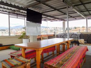 a wooden table and chairs in a room with windows at Hotel Las Americas in Cuenca