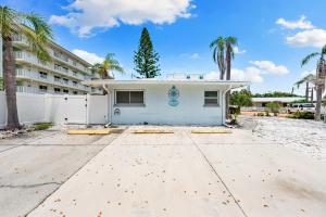a house with palm trees in front of a building at Sun and Sea By Beachside Management in Siesta Key