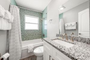 a bathroom with a sink and a toilet and a window at Sun and Sea By Beachside Management in Siesta Key +28 photos