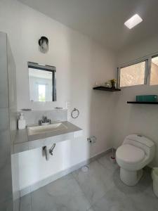 une salle de bains blanche avec toilettes et lavabo dans l'établissement Departamento TUL, à Mérida