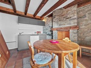 een keuken met een houten tafel in een kamer bij PO Petite Ourses Suite - Anzere Slopeside - Swiss Alp in Anzère