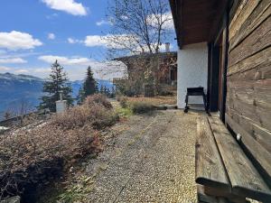 een bank aan de zijkant van een gebouw bij PO Petite Ourses Suite - Anzere Slopeside - Swiss Alp in Anzère +4 foto's