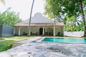 a villa with a swimming pool and a building at Matt-Jay Villa -Baddegama in Baddegama