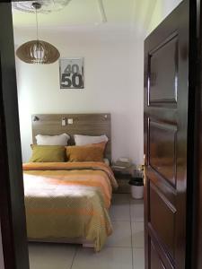 a bedroom with a bed and a clock on the wall at Résidences MV in Kofa