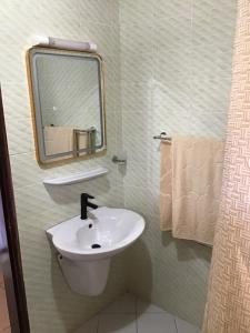 a bathroom with a sink and a mirror and towels at Résidences MV in Kofa +14 photos