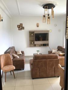 a living room with two couches and a flat screen tv at Résidences MV in Kofa