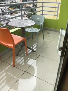 a table and two chairs sitting on a balcony at Résidences MV in Kofa