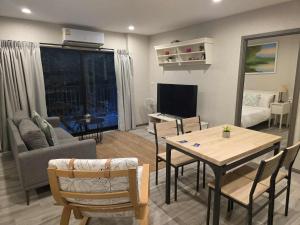 奈扬海滩2 Bedroom Apartment in Naiyang - The Title Residences, Naiyang的客厅里有一张桌子和一张沙发